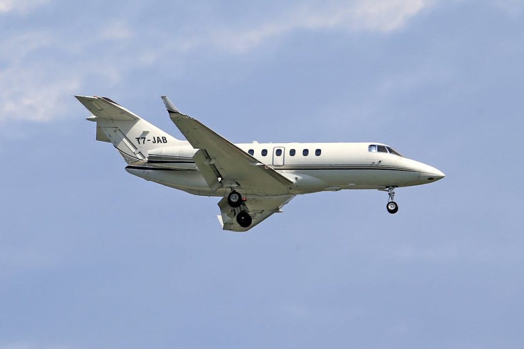 pexels photo 11644230 Hawker 800 business jet flying through the clear blue sky, showcasing aviation in motion.