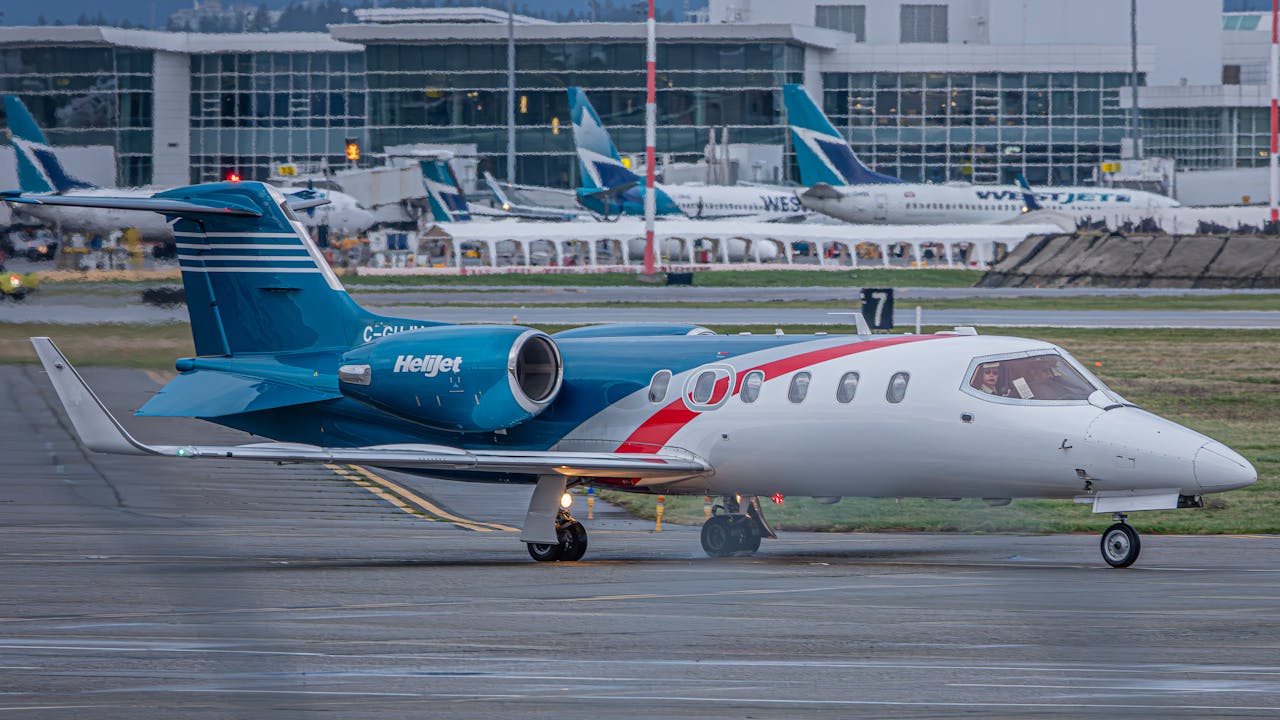 gallery-01 A Helijet aircraft positioned on an airport tarmac with terminal in the background.