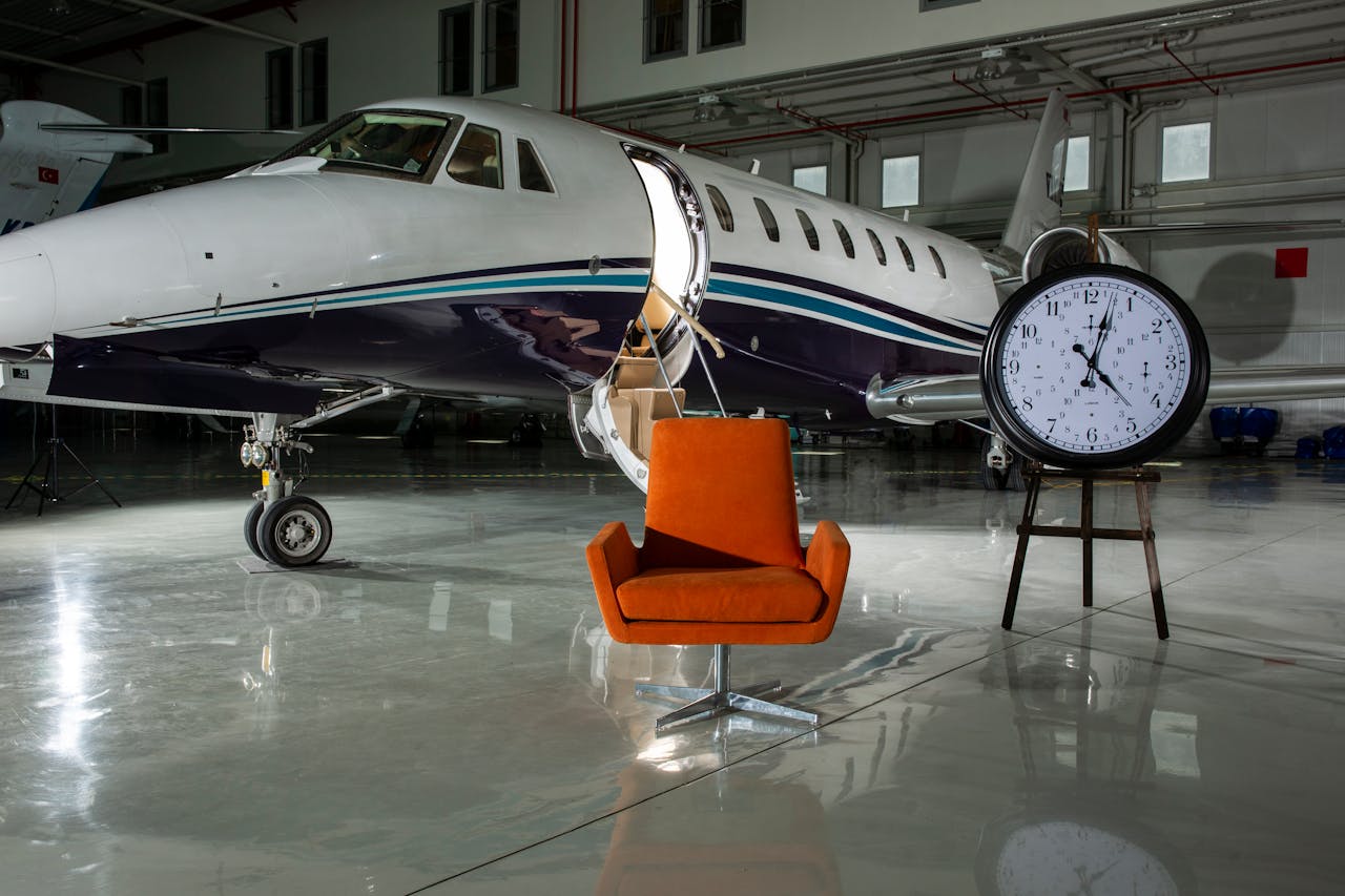 portfolio-01 A private jet and modern furnishings inside an illuminated airport hangar.